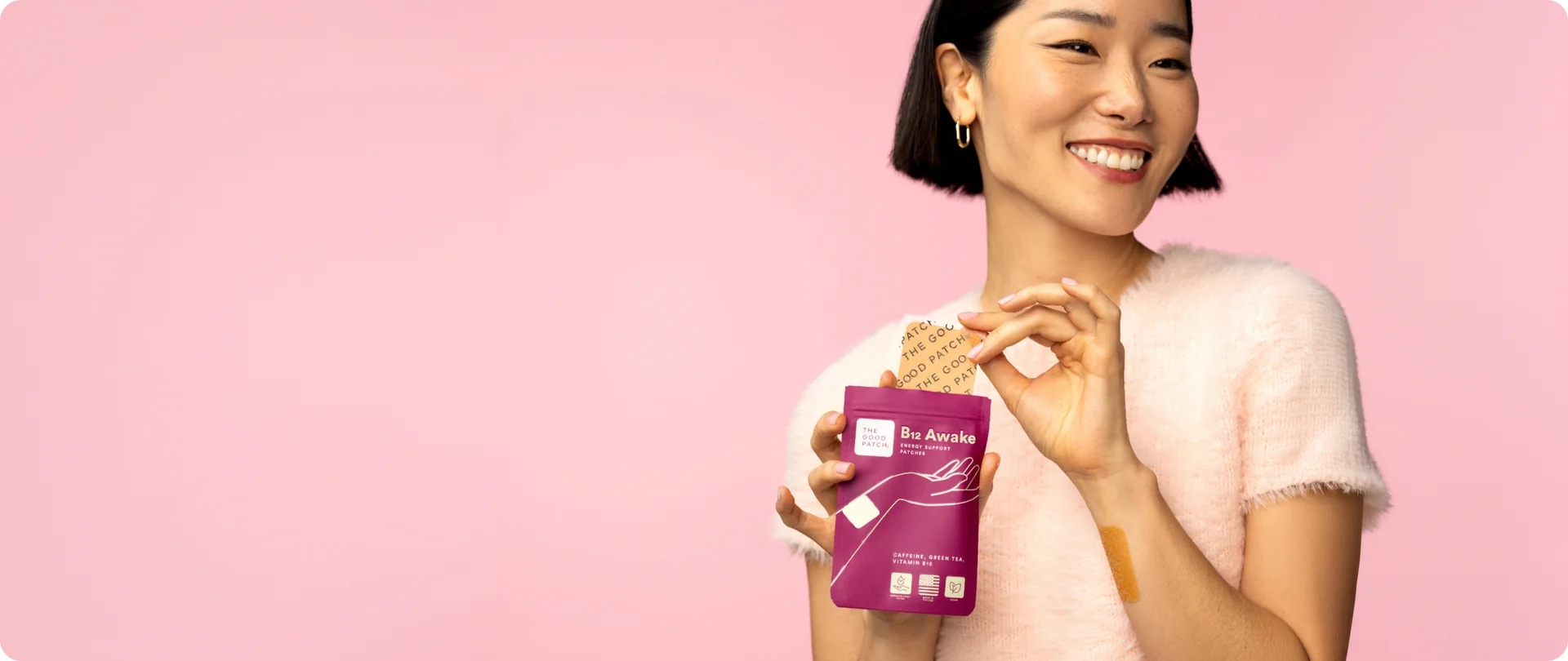 Woman holding a B12 Awake pouch and peeling a patch