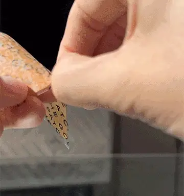 A hand peeling a Good Patch wellness patch from its backing